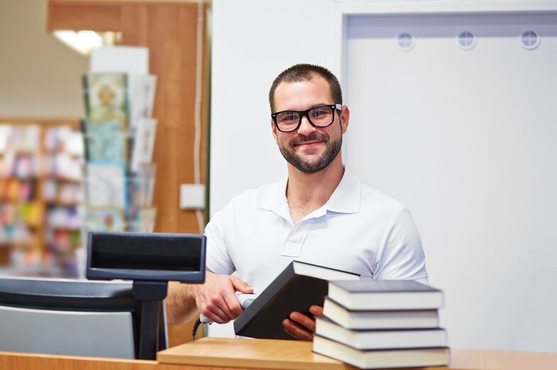 Employee scans book at checkout 