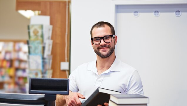 Employee scans book at checkout 