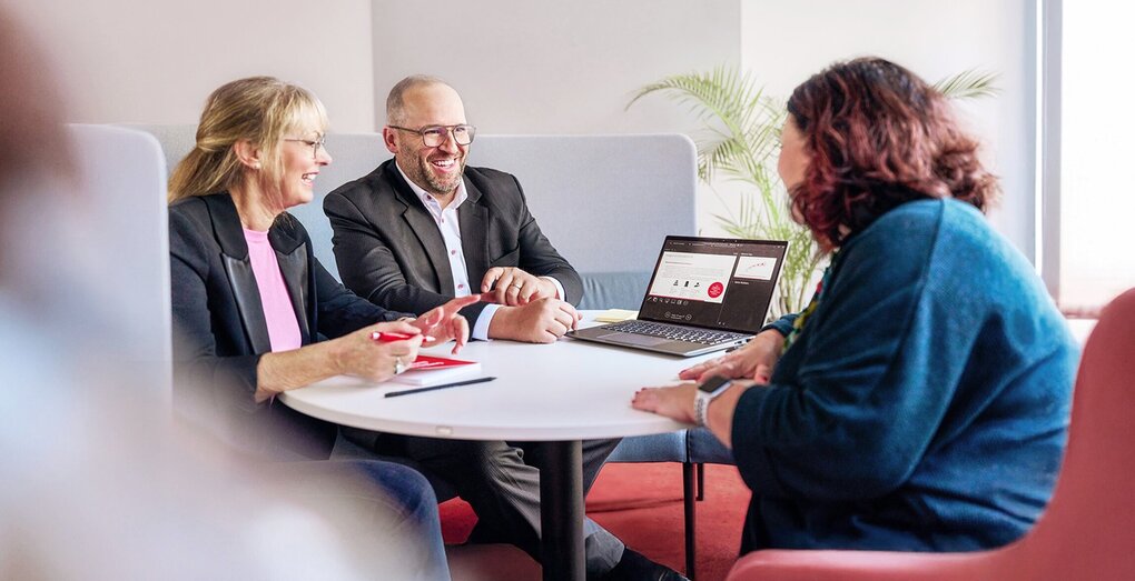 Group discussing financial data in front of large screen