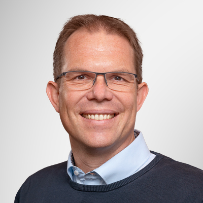 Portrait of a person in business attire against a neutral background