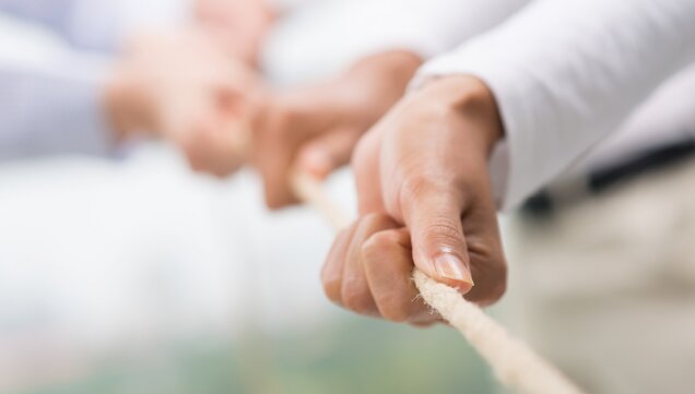 Hands pulling together on a rope 