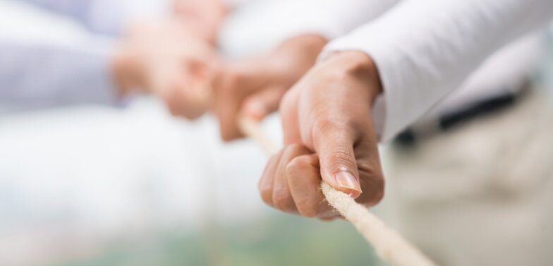 Hands pulling together on a rope 