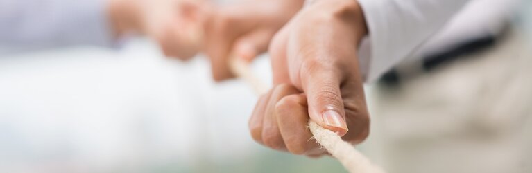 Hands pulling together on a rope 